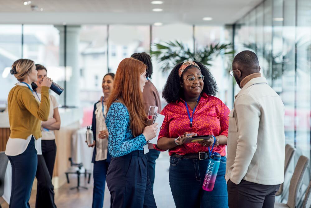 people with lanyards standing and networking